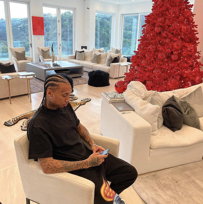Tyga's bright white living room was contested with a bold solid red Christmas tree over the festive season.