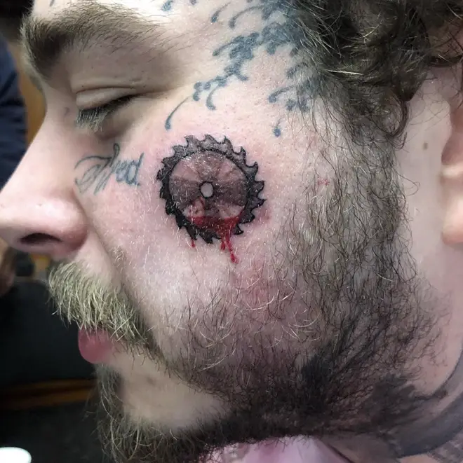 Post Malone shocked fans by getting at new tattoo of a bloody buzzsaw on his fans.
