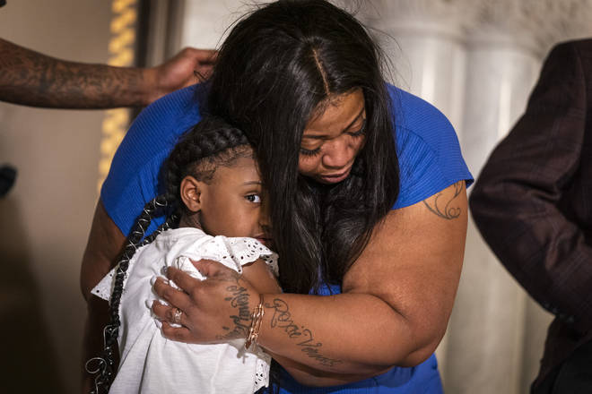 George Floyd's six-year-old daughter Gianna Floyd gives her mother Roxie Washington a hug during a press conference at Minneapolis.