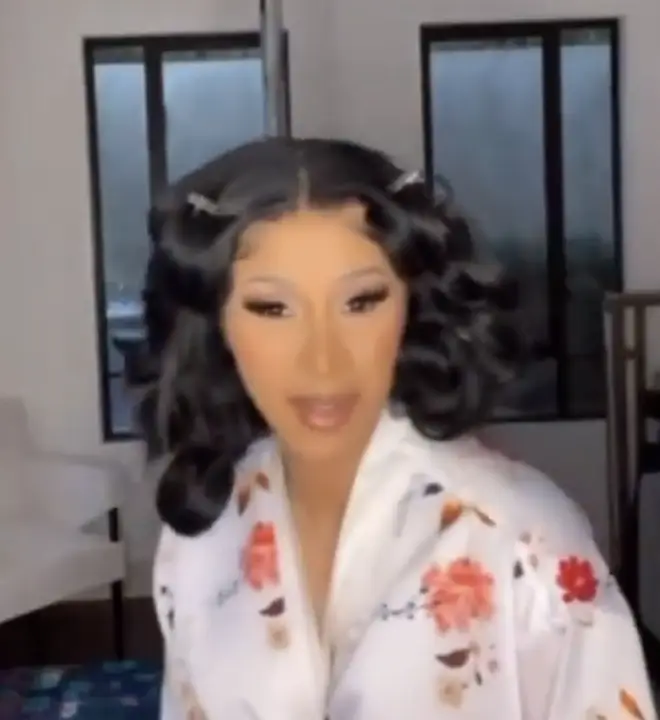 Cardi B enters the video in her white silky floral robe