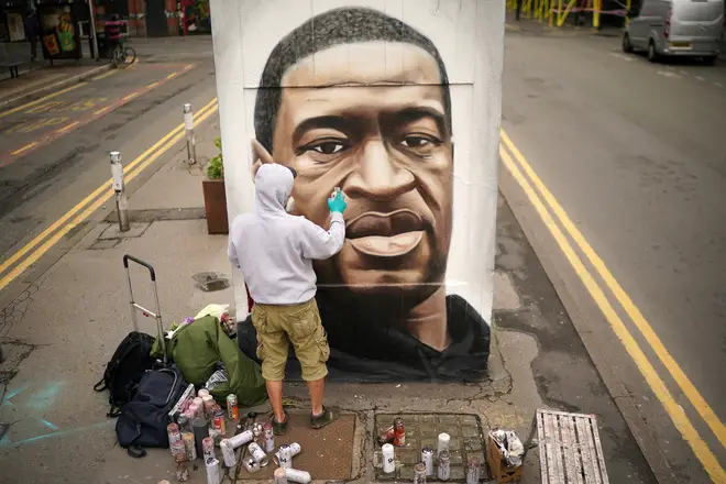 Graffiti artist Akse spray paints a mural of George Floyd in Manchester's northern quarter on June 03, 2020.