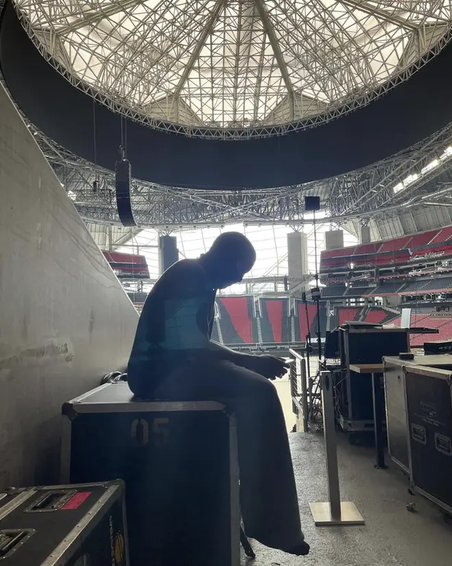 Kanye West shares photo of himself in the Mercedes-Benz Stadium in Atlanta at his listening event.