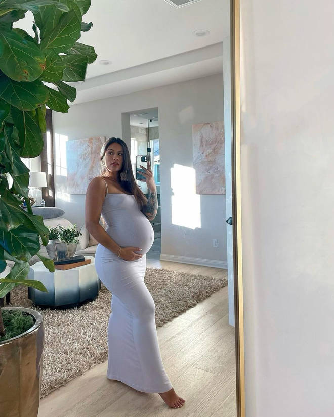 Model and influencer Diamond Brown cradles her pregnant belly.