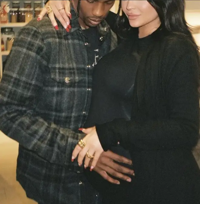 Kylie Jenner shared a photo of of Travis cradling her bump as they posed for a photo together.