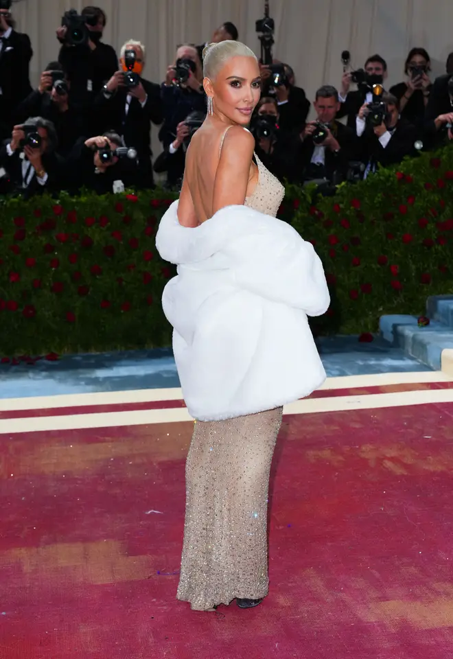 Kim Kardashian pairs iconic Marilyn Monroe dress with a white fur shrug at the Met Gala 2022.