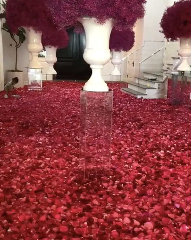 Kylie's sprawling Calabasas mansion was covered in thousands of red roses, which baby Stormi (left) was enamoured by.