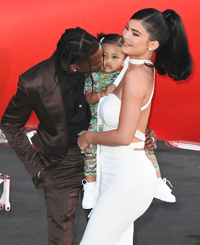 Travis posed with Kylie Jenner and baby Stormi on the brown carpet in LA